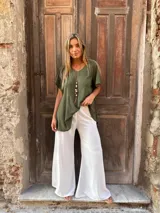 Pantalón blanco de seda, corte sastrero y pierna ancha.