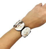 Pulsera elástica hecha de resina con círculos de color verde oliva y verde agua.