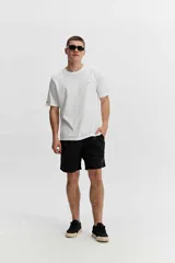 Short de baño negro de corte largo ("long fit"), con cintura elástica, bolsillos laterales y un bolsillo trasero.