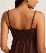 Vestido midi de Blue Steel confeccionado en sarga de algodón, con diseño de corte amplio, escote recto y breteles finos. Presenta una falda con cortes horizontales que aportan volumen y movimiento.