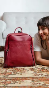 Mochila de cuero sintético color azul con diseño acolchado de rombos en el frente. Cuenta con bolsillo frontal con broche magnético, asa de mano superior y correas regulables. El compartimento principal incluye bolsillos internos con cierre y divisiones.