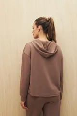 Canguro color beige de la línea Essence, con capucha, corte amplio y detalle de recorte frontal.