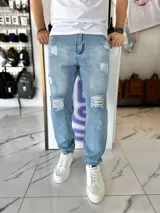 Pantalón mom jean de corte oversize, color celeste claro, con roturas y efecto desgastado en las piernas.