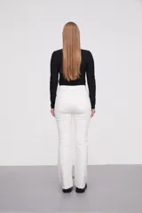 Pantalon jean de tiro alto con corte flare y terminación desflecada en el ruedo. Presenta un diseño clásico de cinco bolsillos con costuras en contraste.