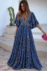 Vestido largo verde con estampado paisley, escote en V profundo, mangas amplias con volados y corte imperio con detalles bordados.