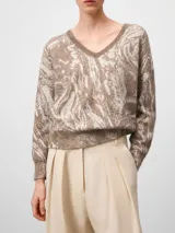 Jersey de punto con cuello en pico y manga larga, confeccionado en tejido jacquard con diseño abstracto. Presenta terminaciones en canalé en puños y cintura, ofreciendo una textura suave y ligera.