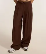Pantalón wide leg de estilo sastre color marrón, con cintura elástica, lazo ajustable y pliegues frontales. Presenta un corte recto y fluido.