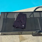 Short de baño rosado con estampado de siluetas negras, cintura elástica con cordón ajustable y logo estampado en la pierna.