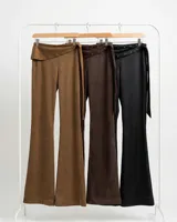 Pantalon negro de corte recto con cintura baja y detalle de solapa con tachas metálicas. Incluye un lazo lateral para ajuste y cierre.