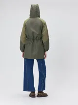 Campera tipo piloto con capucha, cierre frontal con botones y detalle de costuras en zigzag. Presenta cordones ajustables en la cintura y capucha, puños elásticos y logo bordado en el pecho.