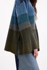 Sweater de punto con diseño en bloques de tonos marrones y tostados, cuello redondo y mangas largas amplias.