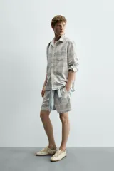 Camisa regular fit confeccionada en tejido de algodón con diseño de cuadros en tonos celestes y beige, cuello con botones, manga larga con puño abotonado y bolsillo de parche en el pecho.