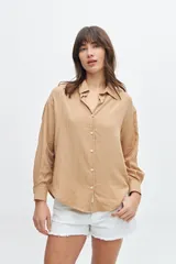 Camisa color beige de corte clásico, con cuello y mangas largas.