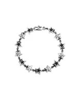 Pulsera de eslabones plateados con dijes en forma de estrella. Las estrellas tienen un centro esmaltado en negro.