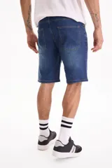 Bermuda de jean de corte clásico con spandex, color azul con lavado medio y costuras en contraste.