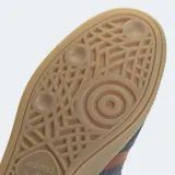 Zapatillas Adidas Handball Spezial, color azul con detalles en marrón. Capellada de gamuza, con las tres tiras clásicas de Adidas en los laterales y suela de goma color caramelo.