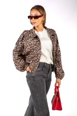 Campera de corte holgado con estampado animal print de leopardo, cuello camisero, cierre frontal y mangas largas con puños elásticos.