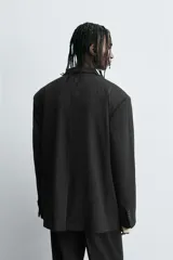 Blazer de corte regular fit con diseño de rayas diplomáticas. Presenta cuello con solapas de pico, cierre frontal de botonadura cruzada, mangas largas con botones en los puños, bolsillos de vivo en el pecho y bolsillos con solapa en la cadera.