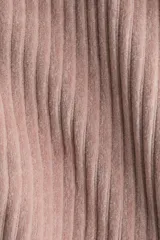 Chaqueta corta de velour acanalado color rosado, con cuello redondo, cierre frontal de botones marrones y dos bolsillos de parche con botón en la parte delantera. Presenta hombros caídos y mangas largas.