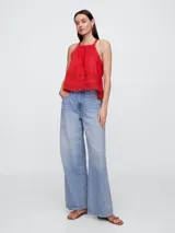 Musculosa de corte halter color rojo, con detalles de encaje en el escote y en la parte inferior. Presenta un diseño holgado y ligero.