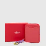 Tarjetero de charol color fucsia, con cierre perimetral y tirador de cordón morado con argolla verde. Incluye caja de presentación roja.