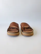 Sandalias bajas de cuero marrón con estampado animal print en las tiras.