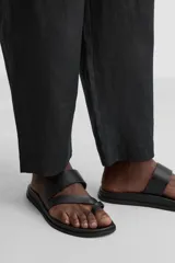 Sandalia de cuero negra con dos tiras anchas en el empeine y tira para el dedo gordo.