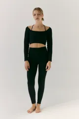 Top de manga larga confeccionado en tejido seamless, con diseño de cuello cuadrado y tirantes finos tipo espagueti. Presenta una textura acanalada y un corte cropped que se ajusta al cuerpo.