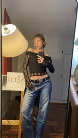 Top negro de encaje con escote bardot y mangas largas acampanadas.