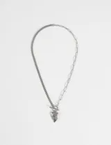 Collar de acero quirúrgico con diseño asimétrico, compuesto por una mitad de cadena de eslabones pequeños y otra mitad de cadena de eslabones alargados. Incluye un dije de corazón con grabado central y cierre frontal tipo barra en T.