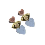 Par de aros colgantes con forma de ojo y corazón. El ojo es negro con detalles dorados y el corazón es de color celeste con glitter.