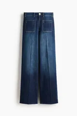 Jeans de tiro alto en denim de algodón con leve stretch, corte wide leg de piernas amplias, bolsillos parche delanteros y raya marcada en el frente.