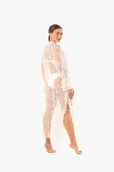 Vestido playero largo de encaje blanco con volados, mangas largas, abertura frontal con lazos para cerrar y aberturas laterales.