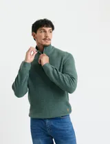 Sweater de punto inglés color verde, con cuello alto y cierre frontal parcial metálico. Diseño de manga larga con puños y ruedo acanalados.