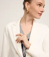 Blazer femenino de sastrería confeccionado en tejido Punto Roma, con cuello solapa, cierre frontal con ganchos y botones decorativos dorados con escudo grabado.