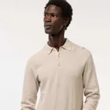 Suéter de punto color beige claro, con cuello polo y tapeta de tres botones. Presenta un tejido texturizado de punto fantasía y puños y bajo acanalados.