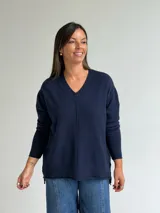 Sweater de punto en color azul marino, con escote en V, manga larga con puños acanalados y costura central vertical en el frente.