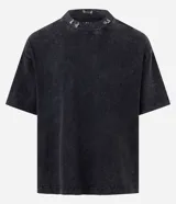 Remera de algodón con efecto lavado, cuello alto y detalle de piercings metálicos en el escote. Presenta un corte holgado y mangas cortas.