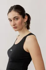 Musculosa de tejido rib color beige con detalles marrones en los bordes del cuello y sisas. Cuenta con el logotipo de la marca bordado en el pecho.