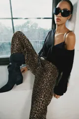 Pantalón bombacho de tiro medio con estampado animal print, bolsillos delanteros, bajo con puño y cierre frontal con cremallera y gancho metálico.