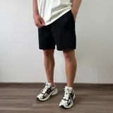 Short de algodón negro con bolsillos laterales y terminación deshilachada en el ruedo.