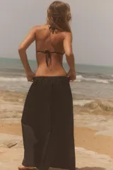 Pantalón negro de tiro medio, estilo culotte, con cintura elástica fruncida y piernas muy anchas. Posee bolsillos laterales ocultos.
