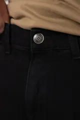 Jean mom de corte holgado color negro, confeccionado en denim de algodón con diseño clásico de cinco bolsillos y tiro medio.