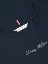 Remera de algodón de corte regular, con cuello redondo y mangas cortas. Presenta el logo de la marca bordado en el centro del pecho y la bandera distintiva de Tommy Hilfiger bordada en la manga.