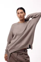 Sweater de punto con cuello redondo, mangas largas con hombros caídos y silueta relajada.