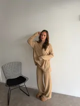 Buzo de punto color marrón chocolate, con cuello redondo y diseño holgado de manga larga con textura de trenzas verticales.