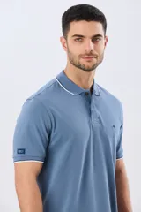 Remera polo de piqué azul marino, con cuello y puños de mangas cortas con ribete blanco en contraste, cierre frontal de dos botones y pequeño logo bordado en el pecho.