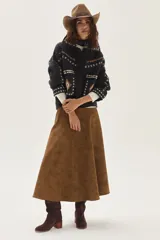 Campera de lana merino hervida en color crudo, con diseño de cuello camisero, cierre frontal de botones y bolsillos frontales. Presenta bordados artesanales con motivos geométricos en tonos marrón y azul en el frente, espalda y mangas.