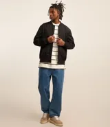 Campera bomber color beige, con cuello alto, cierre frontal con cremallera, bolsillos laterales y puños y cintura elastizados.