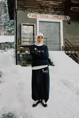 Pantalón de felpa azul marino con tiro alto, cintura elástica con cordón ajustable y diseño de pierna ancha. Presenta un estampado frontal con el logo de St. Moritz y un sol amarillo.